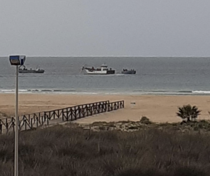 Coronavirus... gamberetti e aragoste. Pescherecci sotto costa a Conil de la Frontera, vicino Vejer de la Frontera