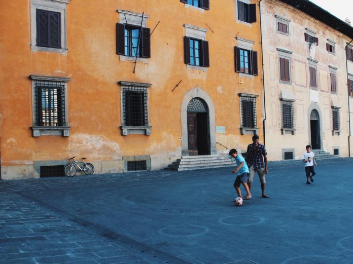 In tre giocano vicino a un edificio di cemento