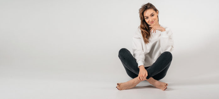 Portrait of a young woman, sitting, cross-legged in Lotus position