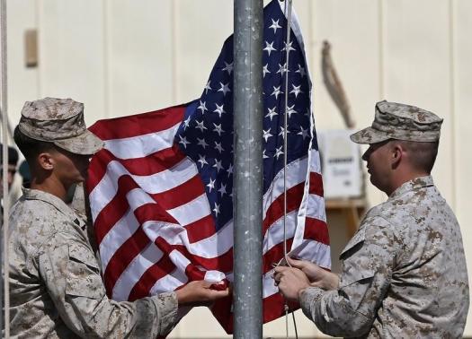 U.S. Marines lower their flag during a handover ceremony, as the last U.S. Marines unit and British combat troops end their Afghan operations, in Helmand