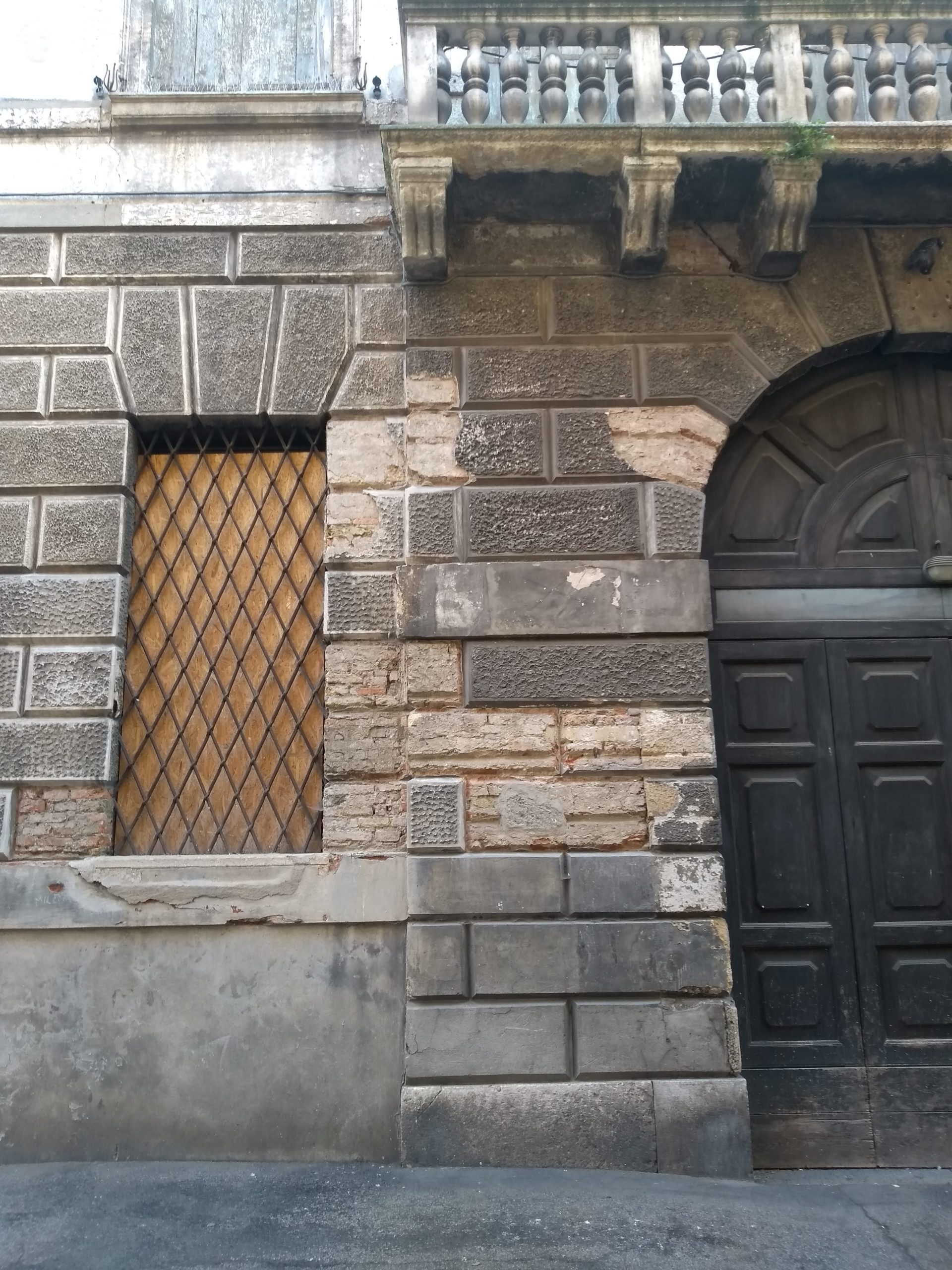 L'ingresso di Palazzo Serbelloni e una delle finestre tamponata con assi di legno