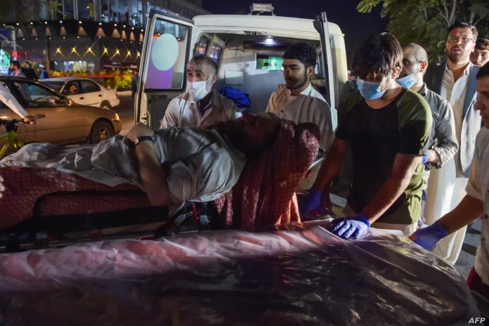 Volunteers and medical staff bring an injured man for treatment after two powerful explosions outside the airport in Kabul on Aug. 26, 2021 (foto da Voice of America)