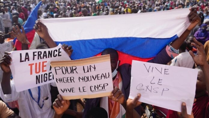 Manifestanti pro golpisti in Niger con la bandiera russa e cartelli contro la Francia