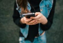 Recensioni online, Udicon promuove le nuove linee guida Antitrust ma chiede verifiche Linee guida sulle recensioni online, persona non riconoscibile consulta uno smartphone