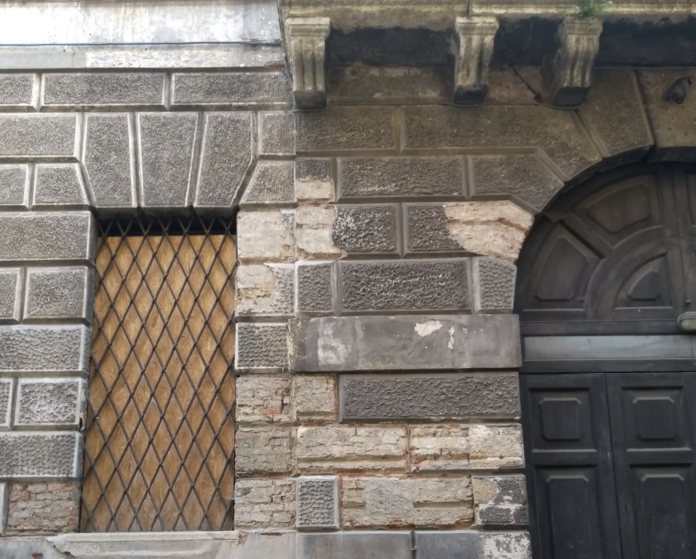 L'ingresso di Palazzo Serbelloni, di proprietà di Ipab Vicenza, e una delle finestre tamponata con assi di legno