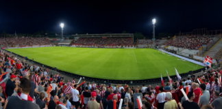 Il Vicenza calcio saluta subito la Coppa Italia: il Catania in crisi economica ma “incassa” la qualificazione ai rigori Lr Vicenza calcio allo stadio Romeo Menti in notturna (elaborazione AI per ViPiu.it)