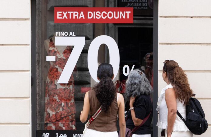 Saldi estivi 2026 e negozi di vicinato Saldi estivi 2026 davanti alla vetrina di un negozio