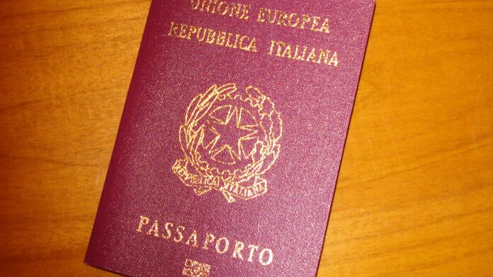 Passaporto italiano e mobilità dei laureati Fuga dei laureati italiani, passaporto su un tavolo