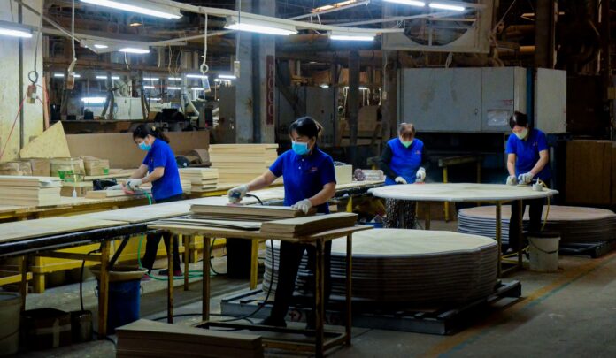 Lavorazione industriale nel settore legno-arredo Contratto legno-arredo, lavoratori in una fabbrica del legno