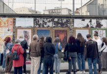 Schio diventa una galleria a cielo aperto: poster art in sei vie fino al 31 ottobre Poster art a Schio, visitatori osservano le opere affisse lungo una strada cittadina