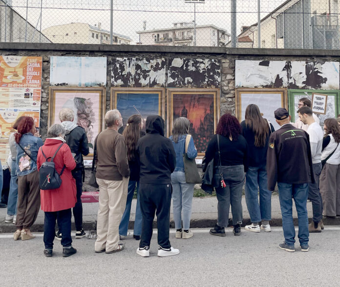 Schio diventa una galleria a cielo aperto: poster art in sei vie fino al 31 ottobre Poster art a Schio, visitatori osservano le opere affisse lungo una strada cittadina